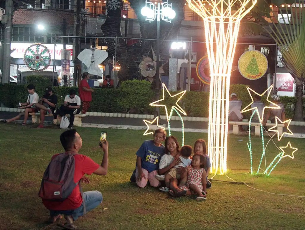 A Filipino family enjoying the Christmas lights on a December evening.